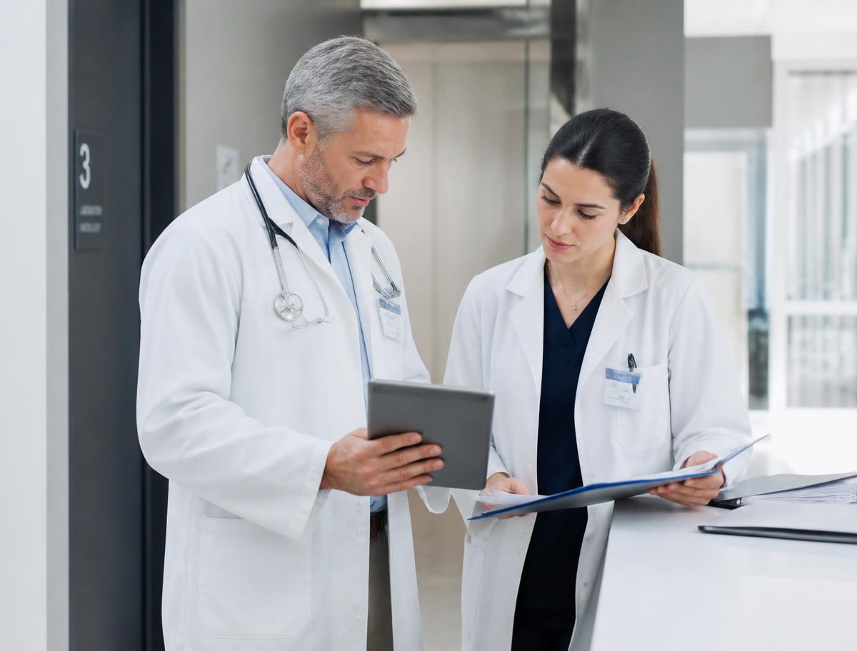 Due professionisti sanitari che confrontano documenti e dati clinici